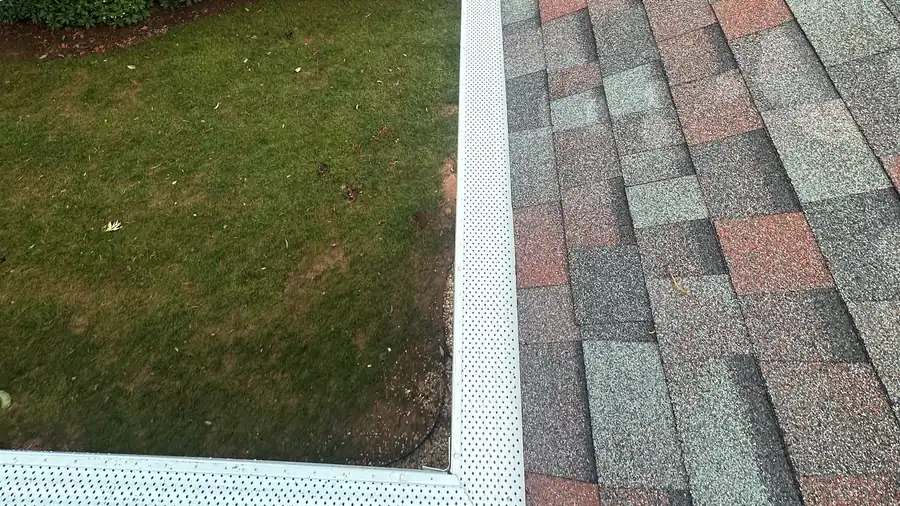 Fine mesh gutter guard running along the eave and up the valley of a shingled roof, on one of our jobs.