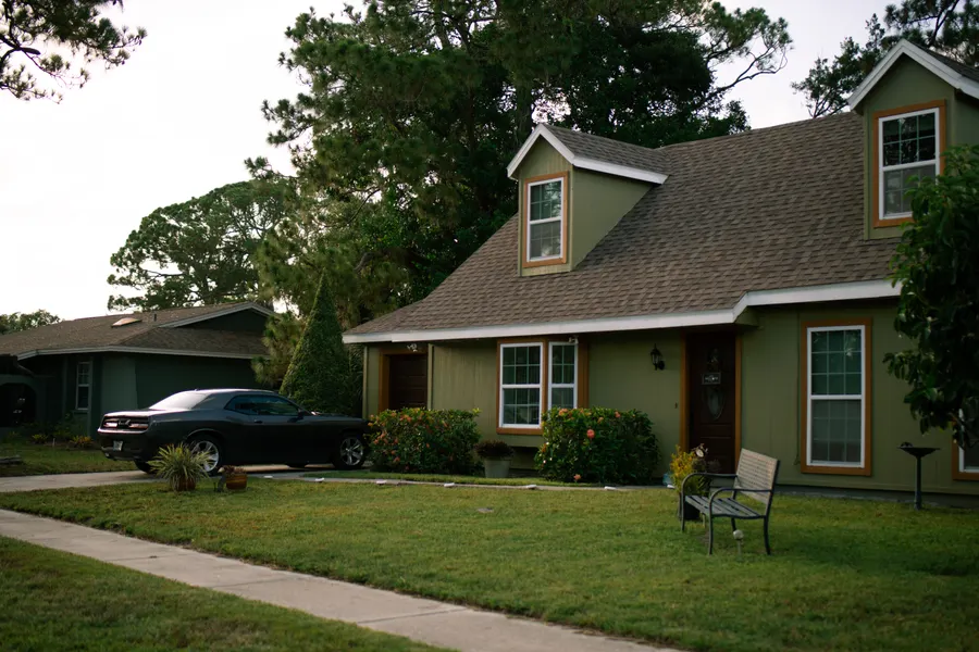 An American home with a deep lawn, downspouts running to the ground at each corner.